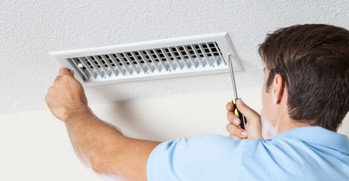 Man cleaning air ducts in home. air hole